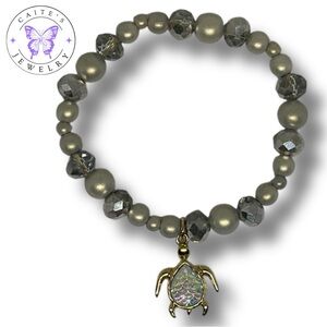 Handmade Gold Elastic Bracelet with Iridescent Grey Beads and a Turtle Charm